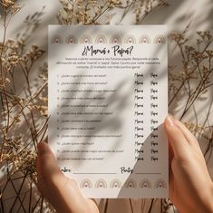 someone is holding up a paper that has been placed in front of some plants and grass