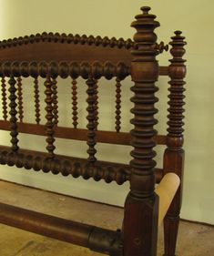 an old bed frame with wooden posts and wood slats on the headboard is shown