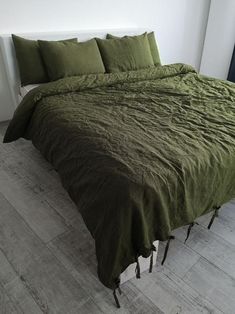 a bed with green sheets and pillows in a room