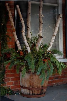 a potted plant sitting on top of a wooden barrel next to a brick building