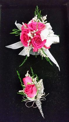 three pink and white flowers are placed on a black surface