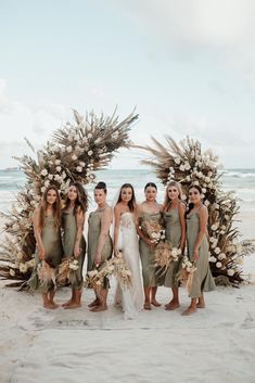 a group of women standing next to each other on a beach