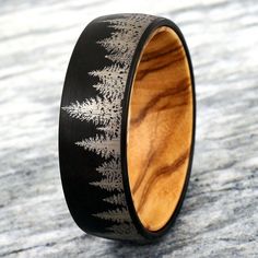 a wooden ring with an intricate design on it's side and black wood inlays