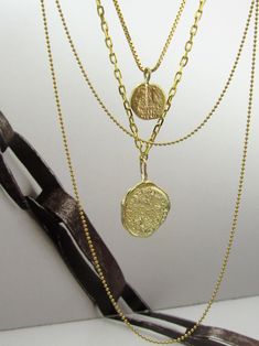 "Necklace details:  * All the necklaces and pendants are made from 14 karats solid yellow gold. First necklace: * Chain length 17.7inc/ 45cm. * Pendant size 0.63x0.67inch/ 16x17mm. Gold layering necklaces. Beautiful gold thick gold necklace, with coin pendant. Designed as a coin found in archaeological excavations The coin is not symmetrical rustic but has a soft look. Second necklace: * Chain length: 17.7inc/ 45cm. * Gold pendant size: 0.4inch/ 11cm. A beautiful pendant with a stamp of a \"shek Thick Gold Necklace, Gold Layering Necklaces, Three Necklaces, Beautiful Gold Necklaces, Layering Necklaces, Gold Necklaces, Gold Necklace Layered, Coin Necklace, Coin Pendant