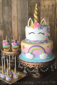 there is a cake with unicorns on it and cupcakes next to it