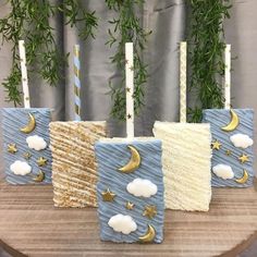 four candles are sitting on a table with clouds, stars and the moon in them