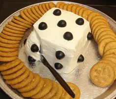 a cake made to look like a dice surrounded by crackers on a platter