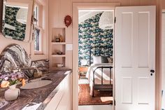 an open door leading to a bathroom with floral wallpaper on the walls and floor