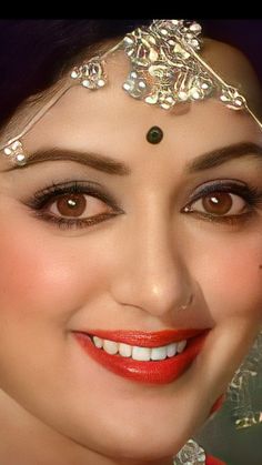 a close up of a woman with makeup on her face and jewelry around her neck