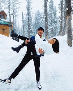 a man carrying a woman on his back in the snow