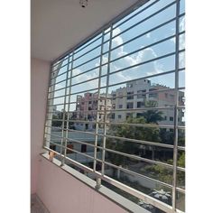 an empty balcony with large windows and buildings in the background