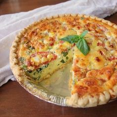 a quiche on a table with a slice missing