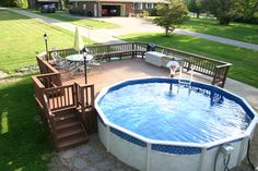 an above ground swimming pool with steps leading up to it and a deck on the other side