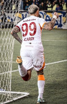 a soccer player is running towards the goalie's net to celebrate his goal