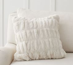 a white pillow sitting on top of a couch