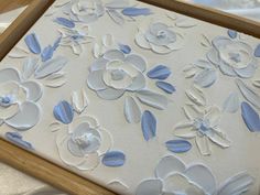 a close up of a flower design on a piece of paper in a wooden frame