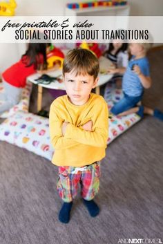 there is a young boy standing with his arms crossed in front of him and two other children sitting on the floor behind him