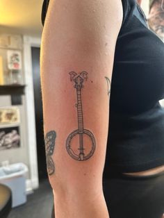 a woman with a tattoo on her arm has a guitar in the shape of a key