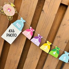 there is a sign that says no 4 photo hanging on the fence with paper dresses