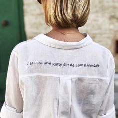 the back of a woman's shirt that says, l'art est une granite de santie meme