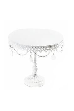 a white cake stand with beaded trimmings and pearls on it's sides