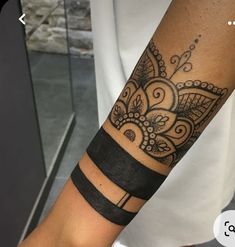 a woman's arm with a tattoo on it and a black band around the wrist