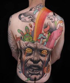 a man with tattoos on his back has an image of a demon in the background