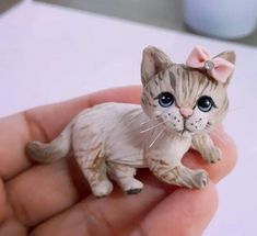 a small cat figurine in someone's hand