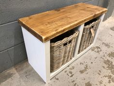 a wooden bench with baskets on it next to a wall