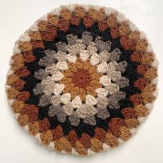 a circular crocheted rug with many different colors