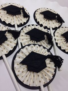 graduation cupcake toppers with black and white tassels on them are ready to be eaten