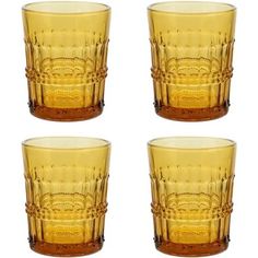 four yellow glass tumblers sitting next to each other