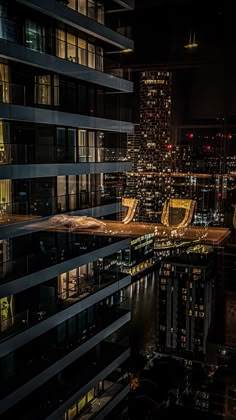 an aerial view of the city at night with skyscrapers lit up and buildings reflected in the water