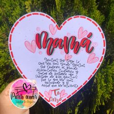 a hand holding up a heart shaped paper cutout with words in spanish and english