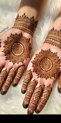 two hands with henna tattoos on them