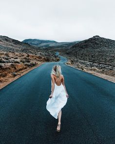 a woman walking down the middle of a road with an instagram message above her