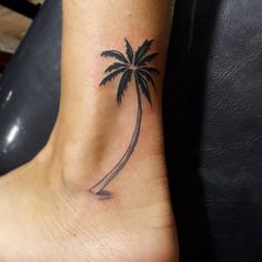 a small palm tree tattoo on the ankle