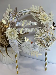 a close up of a cake with flowers and butterflies on it next to two straws