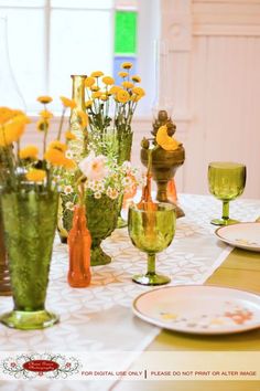 there are many vases with flowers in them on the dining room table set for dinner