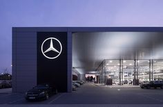 the mercedes dealership is lit up at night