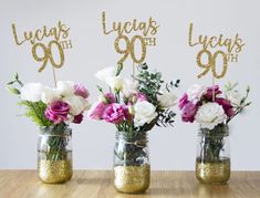 three mason jars with flowers in them on a table