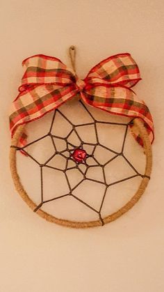 a spider web with a red bow hanging on the wall