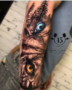 a person with a tattoo on their arm has an owl's face and blue eyes