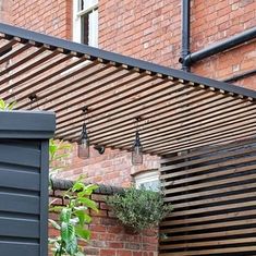 an outdoor patio with wooden slats and potted plants