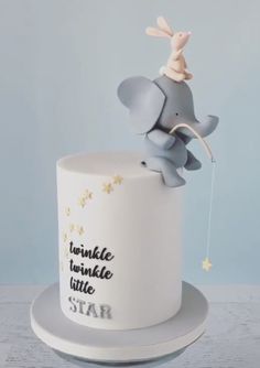 a white and grey cake with an elephant on top that says twinkle twinkle little star