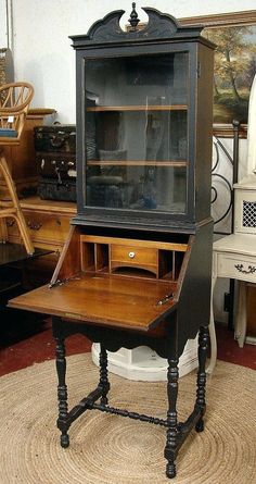 an old fashioned desk with a glass door on it's top and bottom shelf