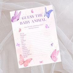 a pink and purple baby shower game with butterflies on the cover, next to a white veil