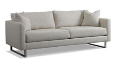 a white couch with two pillows on it's back and the arms folded down