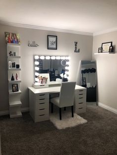 a white desk with two chairs and a mirror on the wall in a room that has carpeted flooring