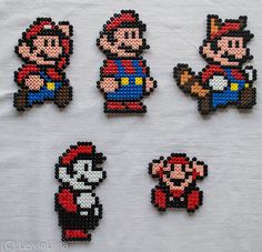 six pixelated mario bros magnets on a white cloth